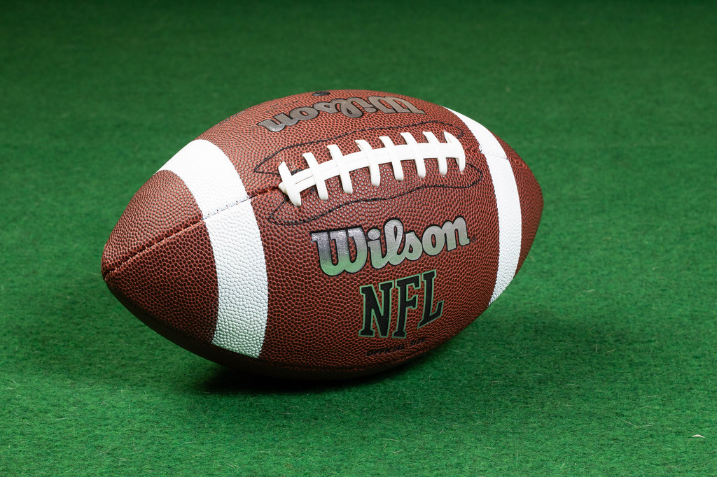 American football ball on grass - Pledge Sports